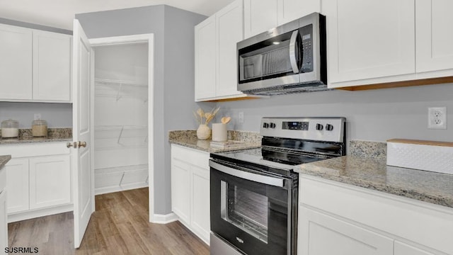 122 Hilton Ct, Egg Harbor Township, NJ 08234 - kitchen featuring appliances with stainless steel finishes, light wood-style flooring, white cabinetry, and light stone counters