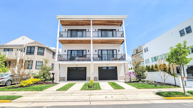view of front of property with an attached garage, fence, a balcony, and driveway