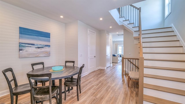 dining space featuring recessed lighting, light wood finished floors, baseboards, and stairway