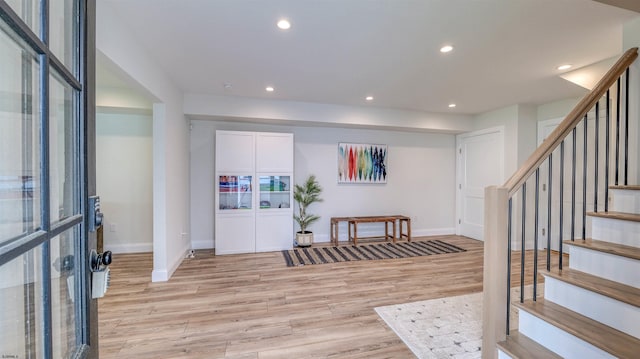 foyer with light wood-style floors, baseboards, recessed lighting, and stairs