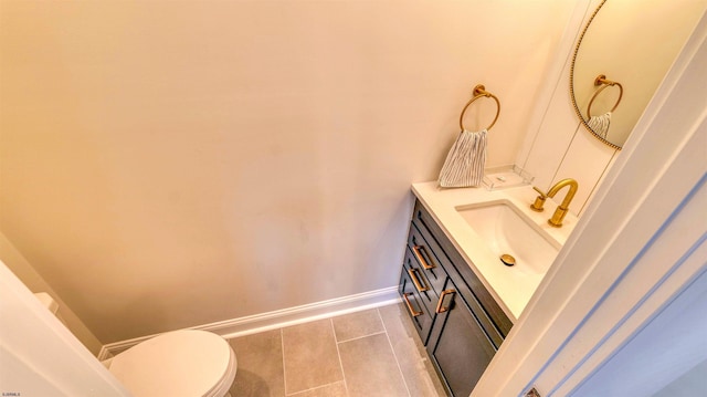 bathroom featuring tile patterned floors, baseboards, vanity, and toilet