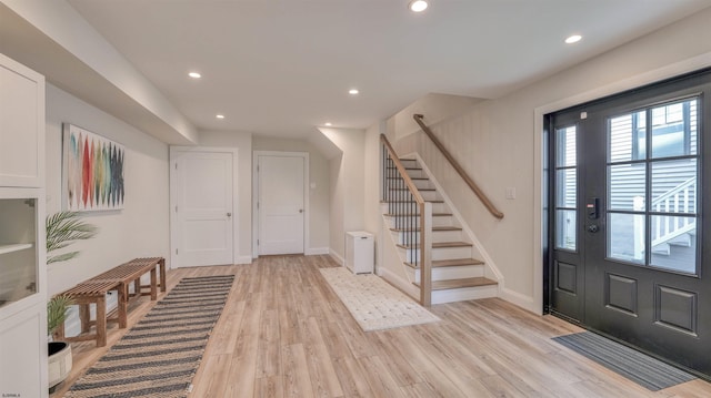 entrance foyer featuring light wood-style floors, recessed lighting, and stairs