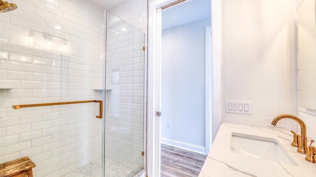 full bath featuring wood finished floors, a stall shower, and vanity