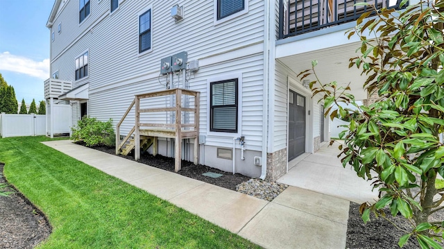 exterior space with a yard, fence, a balcony, and a garage