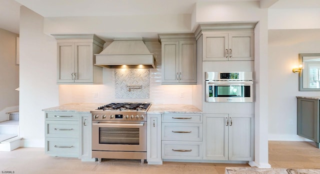 933 Oak Grv, Linwood, NJ 08221 - kitchen with decorative backsplash, premium range hood, baseboards, light stone counters, and stainless steel appliances