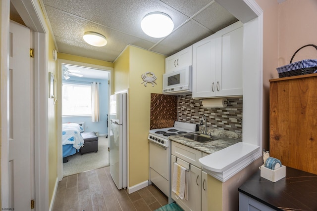 921 Wesley Ave Unit B21, Ocean City, NJ 08226 - kitchen with backsplash, dark wood finished floors, a sink, white cabinets, and white appliances