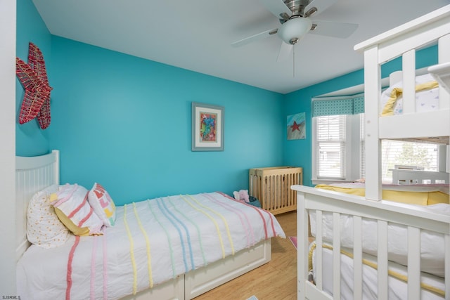 bedroom featuring a ceiling fan, radiator heating unit, and wood finished floors