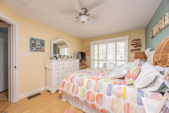 bedroom with light wood-style floors, baseboards, ceiling fan, and visible vents