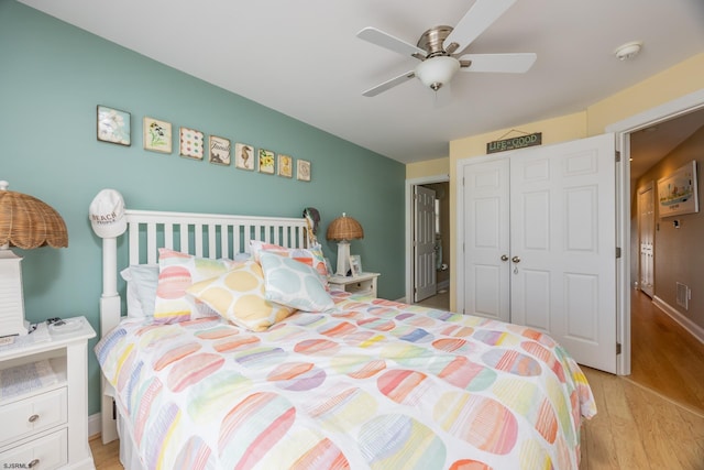 bedroom featuring ceiling fan, visible vents, wood finished floors, and a closet