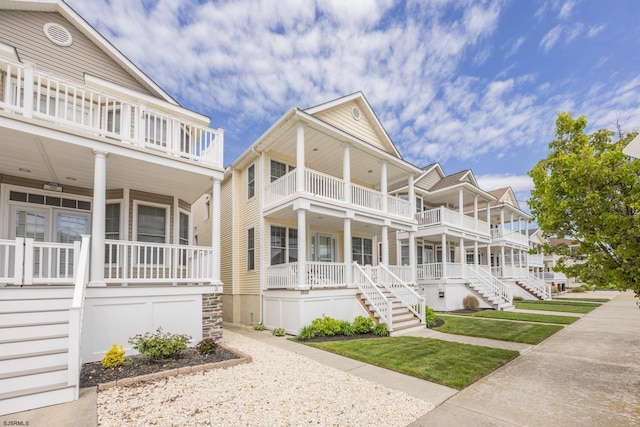 view of front of property with stairs, a balcony, and covered porch