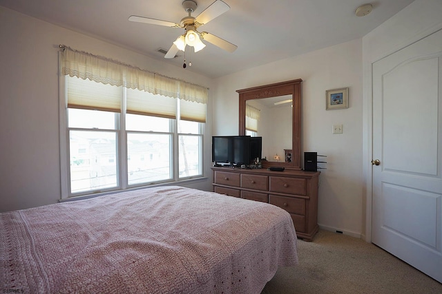 bedroom with ceiling fan, light carpet, and baseboards