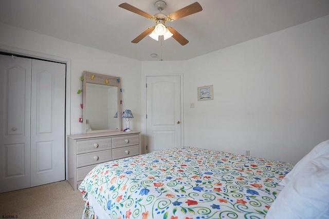 bedroom with a ceiling fan, light colored carpet, and a closet