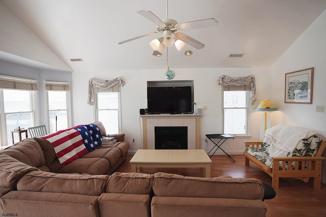 living area featuring visible vents, ceiling fan, wood finished floors, and vaulted ceiling