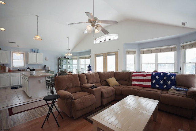 living room featuring visible vents, light wood finished floors, ceiling fan, and high vaulted ceiling