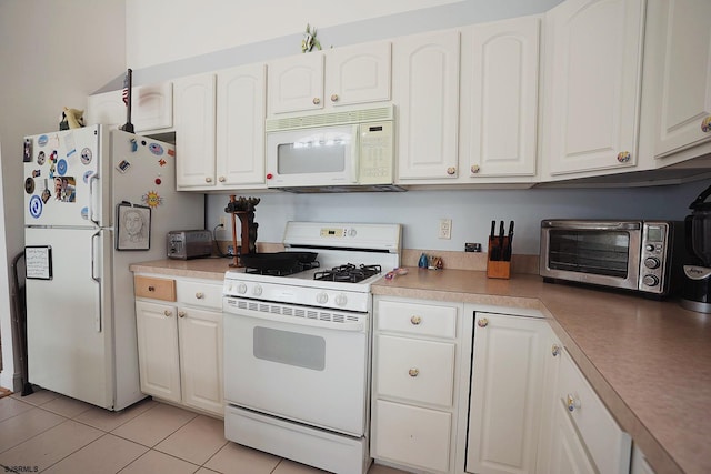 kitchen with a toaster, light tile patterned floors, white appliances, and white cabinetry