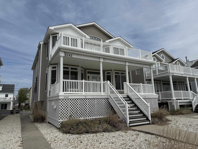 view of front of property with a porch, stairs, and a balcony