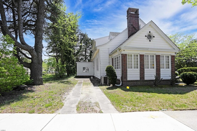 350 S Edgeley Ave, Pleasantville, NJ 08232 - view of front of home featuring a chimney, dirt driveway, central air condition unit, a front lawn, and brick siding