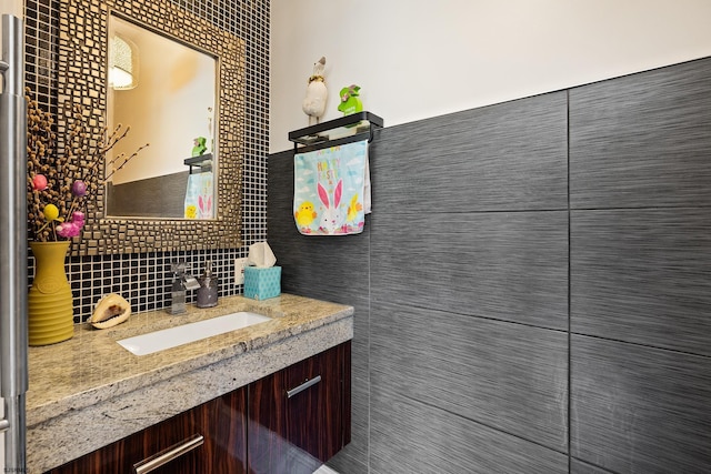 bathroom featuring tile walls, vanity, and tasteful backsplash
