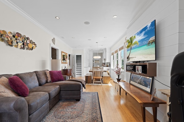 living area with light wood finished floors, ornamental molding, and recessed lighting