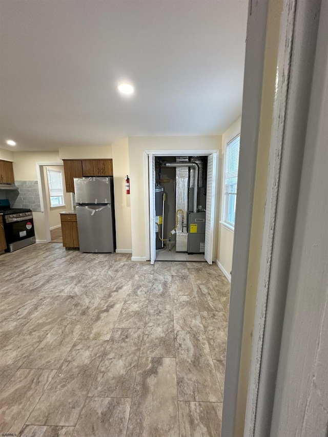 kitchen featuring baseboards, appliances with stainless steel finishes, and plenty of natural light