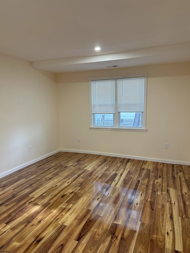 empty room featuring baseboards, visible vents, recessed lighting, and wood finished floors