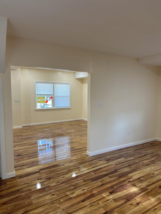 empty room with baseboards and wood finished floors