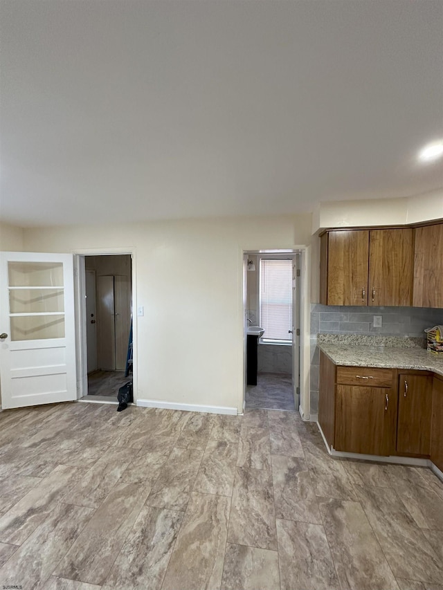 kitchen featuring baseboards and brown cabinets