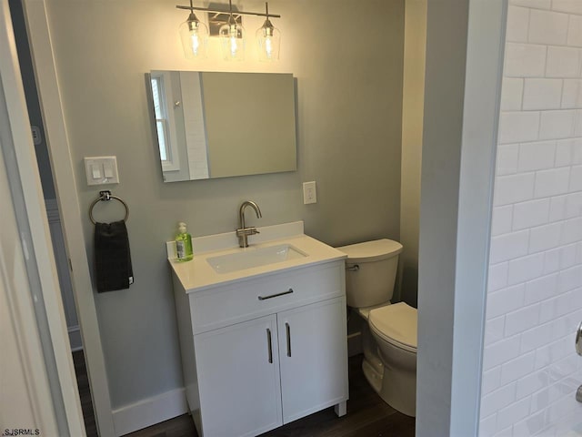 bathroom featuring toilet, wood finished floors, and vanity