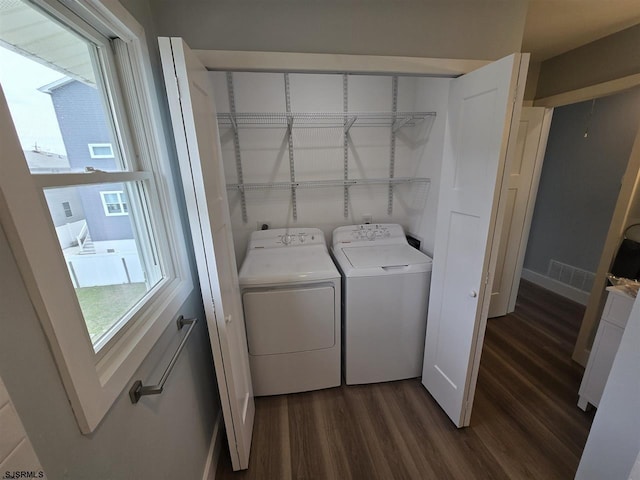 washroom featuring washing machine and dryer, laundry area, dark wood-type flooring, baseboards, and visible vents