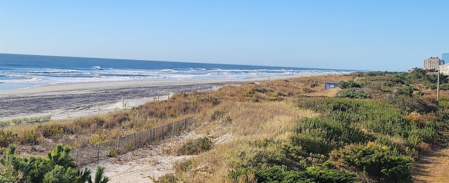 property view of water featuring a beach view and fence