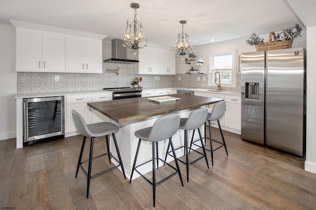 kitchen with appliances with stainless steel finishes, beverage cooler, wooden counters, wall chimney exhaust hood, and open shelves