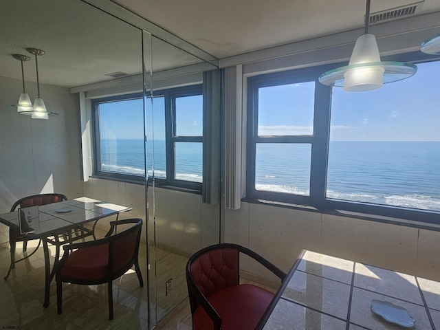 dining room featuring plenty of natural light and a water view