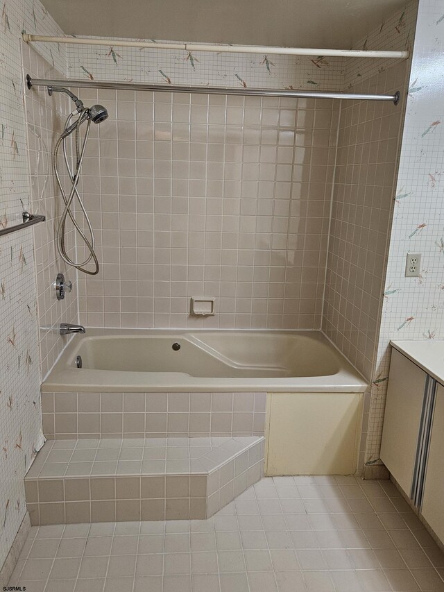 full bathroom featuring tile patterned flooring, tiled shower / bath, and vanity