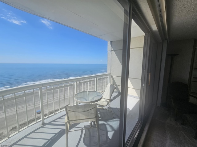 balcony with view of water and beach