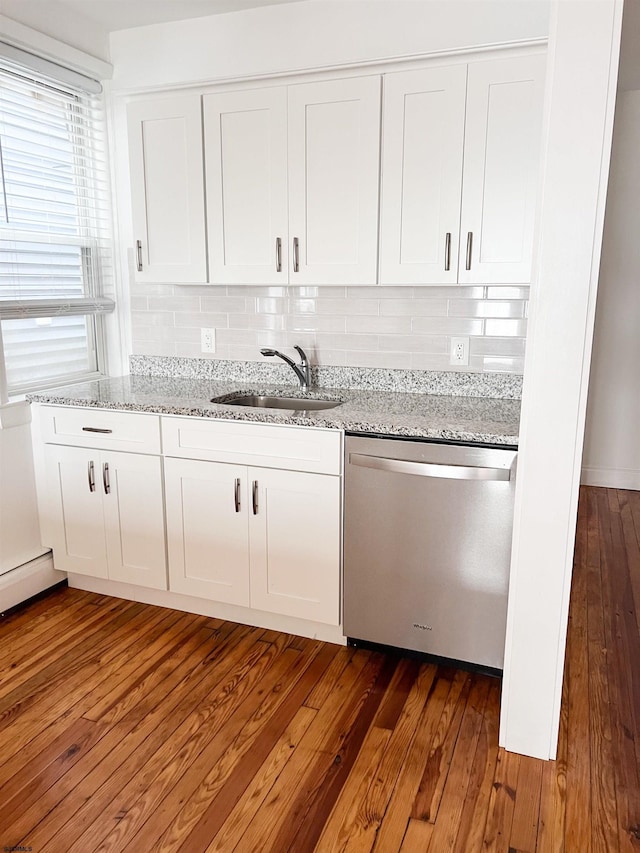 kitchen with stainless steel dishwasher, a sink, dark wood-style floors, white cabinetry, and tasteful backsplash