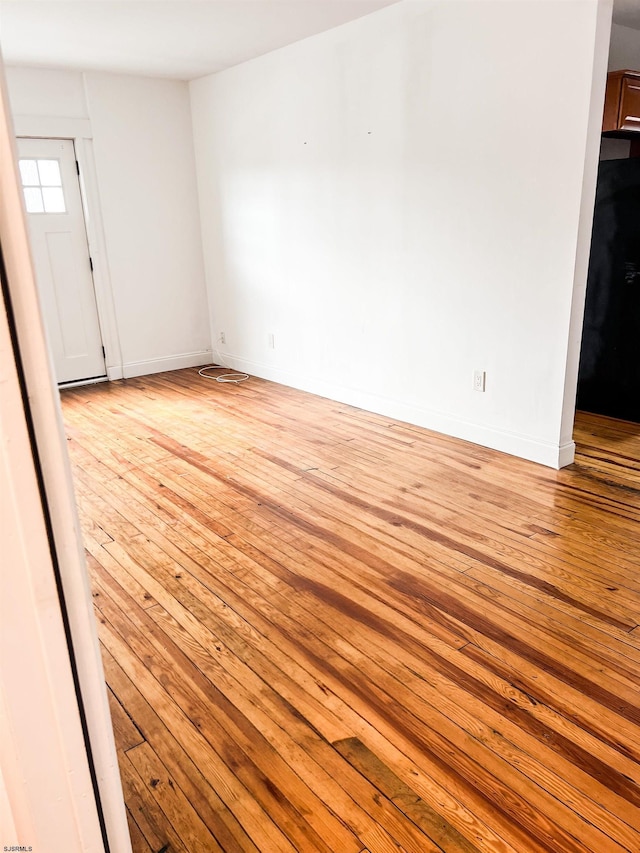 spare room featuring light wood-style flooring and baseboards