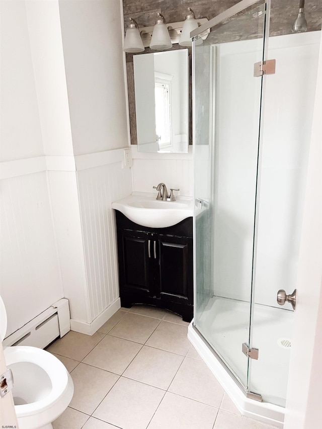 bathroom with a baseboard heating unit, a stall shower, tile patterned flooring, vanity, and wainscoting