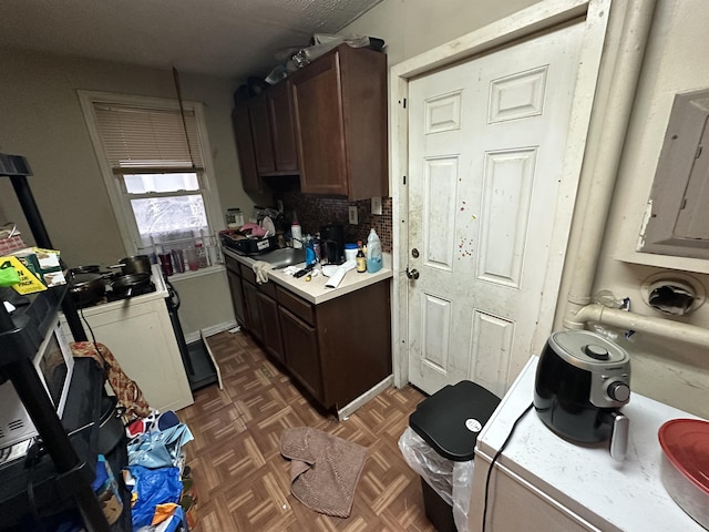 kitchen with light countertops and dark brown cabinetry