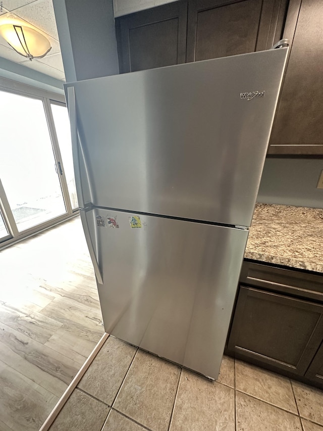 kitchen view of freestanding refrigerator and dark brown cabinets