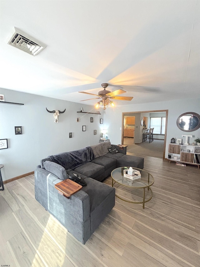 living room featuring a ceiling fan and wood finished floors