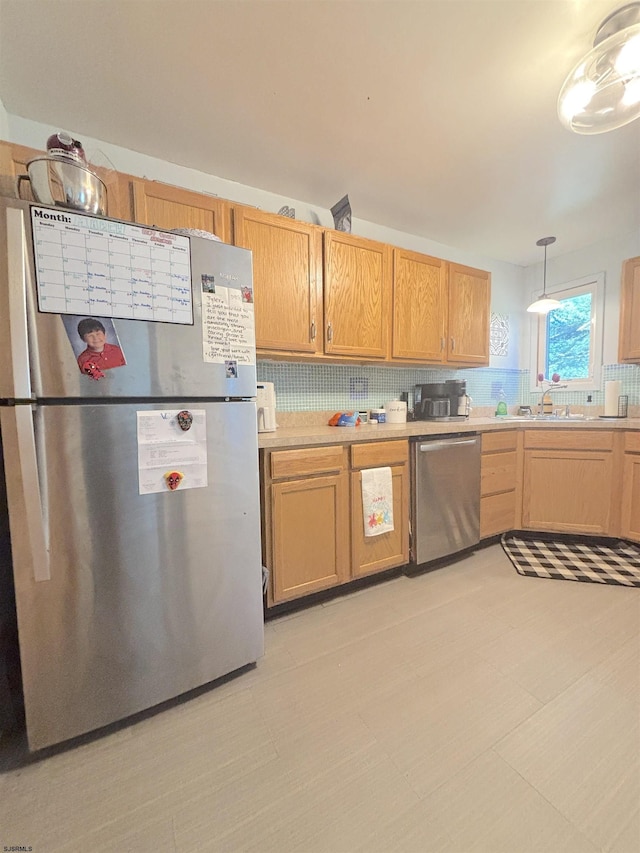 kitchen with appliances with stainless steel finishes, decorative backsplash, light countertops, and decorative light fixtures