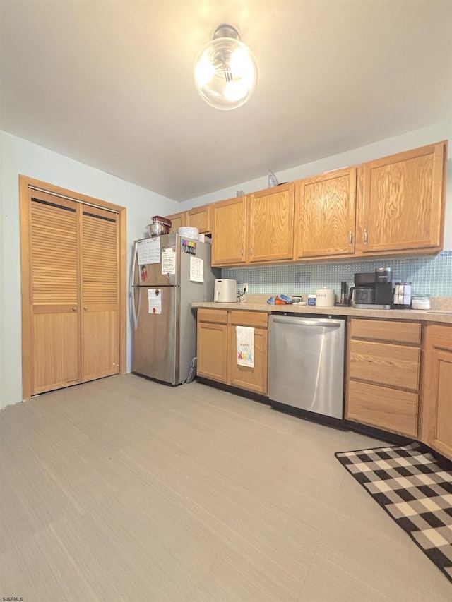 kitchen featuring appliances with stainless steel finishes, light countertops, and decorative backsplash