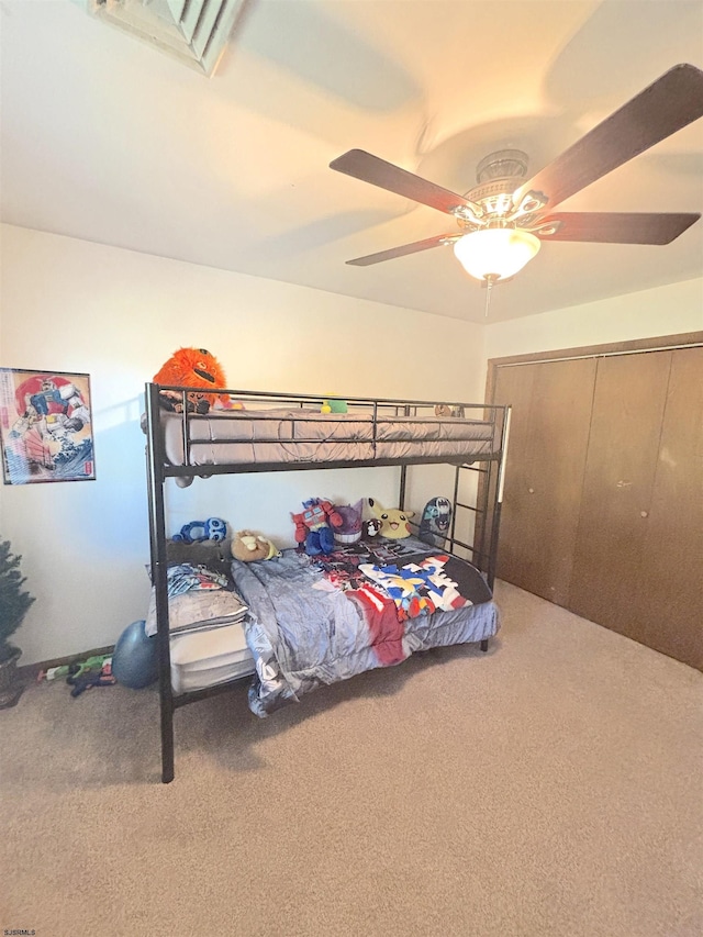 bedroom with carpet, ceiling fan, and a closet