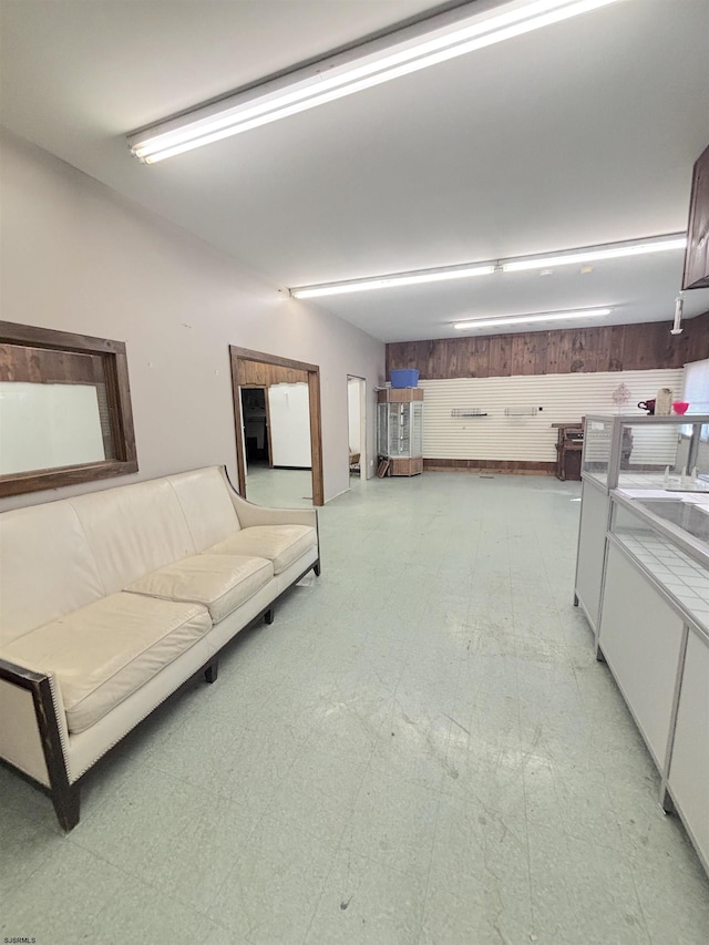 living area featuring light floors and wooden walls