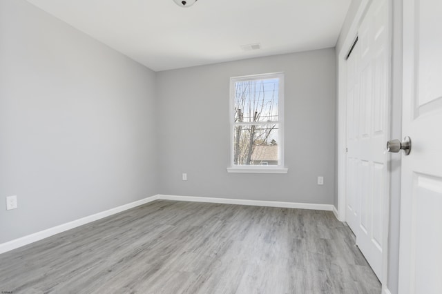 spare room with light wood-style floors and baseboards