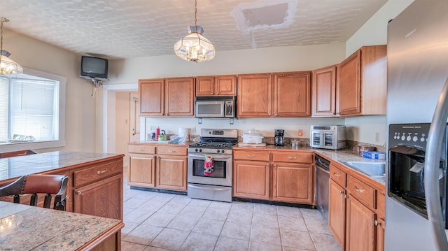 919 Broad St, Pleasantville, NJ 08232 - kitchen with appliances with stainless steel finishes, brown cabinets, pendant lighting, and light tile patterned floors