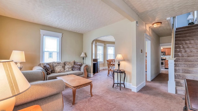 919 Broad St, Pleasantville, NJ 08232 - living room featuring arched walkways, light carpet, a textured ceiling, baseboards, and stairway
