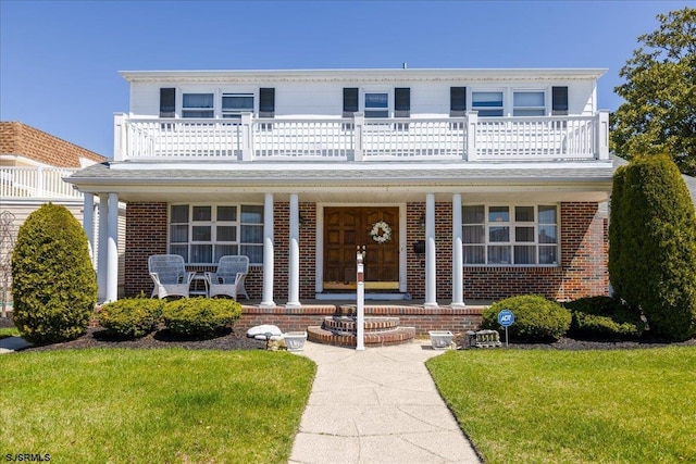 8508 Wellington Ave, Margate, NJ 08402 - view of front facade featuring a balcony, a porch, brick siding, and a front lawn