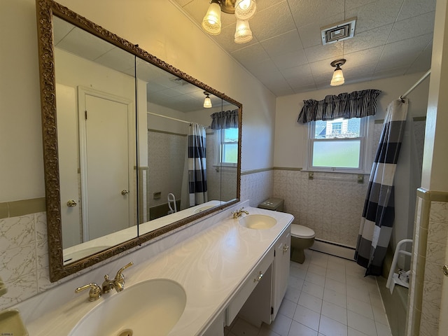8508 Wellington Ave, Margate, NJ 08402 - bathroom featuring baseboard heating, wainscoting, toilet, a shower with shower curtain, and double vanity