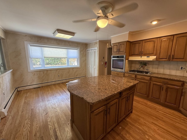 8508 Wellington Ave, Margate, NJ 08402 - kitchen with appliances with stainless steel finishes, a ceiling fan, brown cabinetry, dark stone counters, and under cabinet range hood